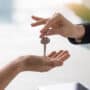Real estate agent giving keys to apartment owner, buying selling property business. Close up of male hand taking house key from realtor. Mortgage for purchasing flat, getting access to own home